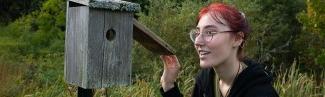 A student checks a bird house